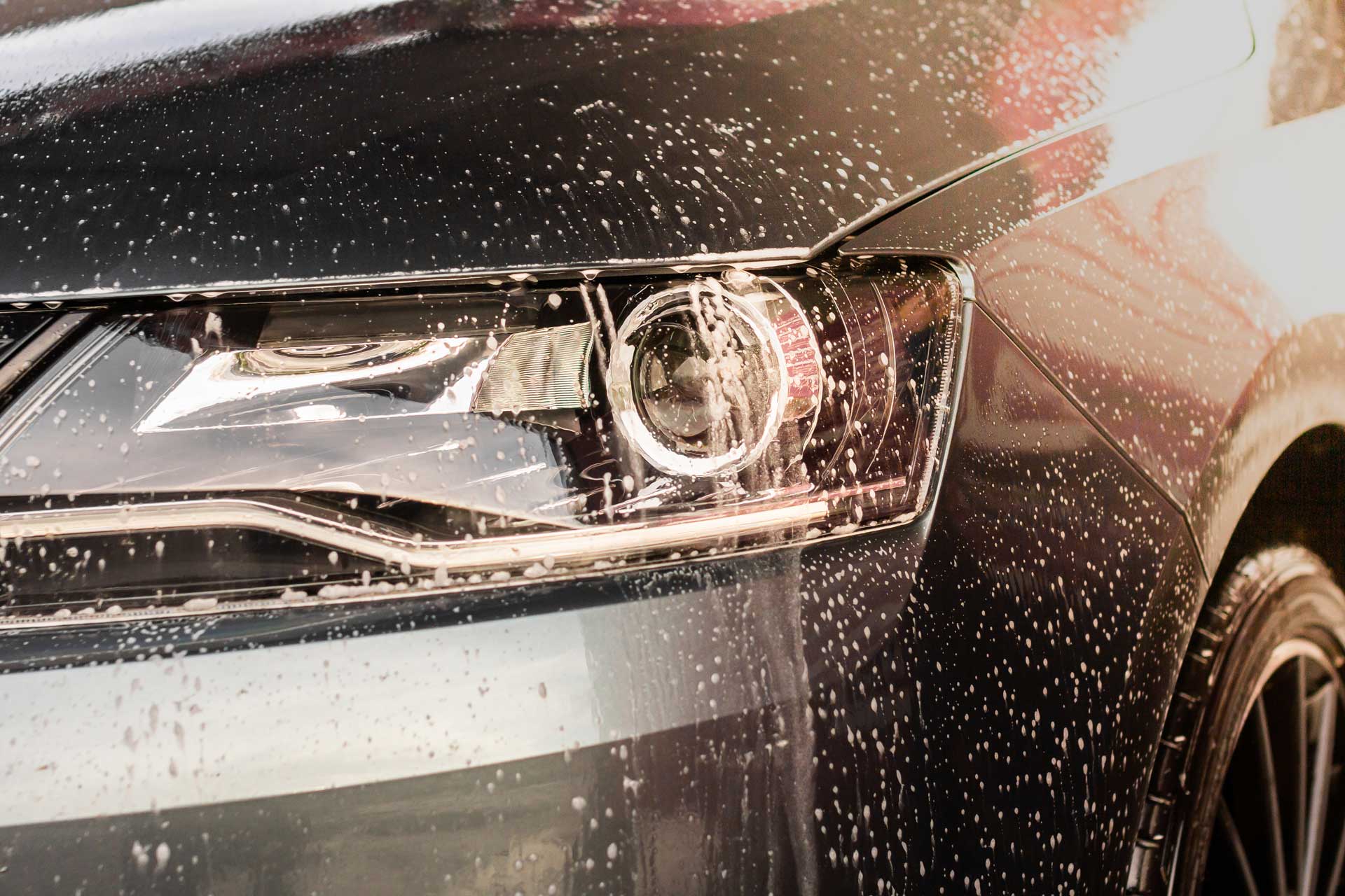 Soapy water beading across a car headlight
